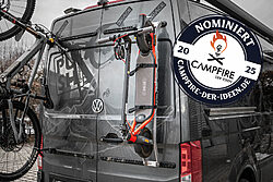 In this picture you can see a camper with vertical rear carriers for an e-scooter and a bicycle. The products are from Pushcomponents and were nominated in the Campfire 2025 ideas competition and presented at CMT 2025.