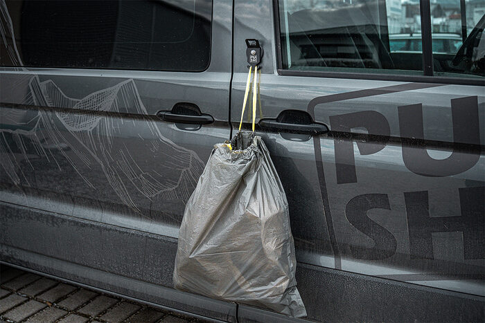 This picture shows the product PUSHrack bottle opener called BLOP, with which you can not only open your bottle but also hang a bin bag on the hook provided on the bottle opener.