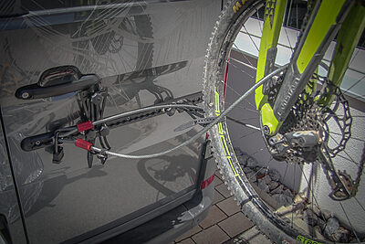 Dieses Bild zeigt, wie du mit den PUSHrack Produkten Lock point, steel cable and padlock dein Rad vor Diebstahl am Fahrradträger schützen kannst.