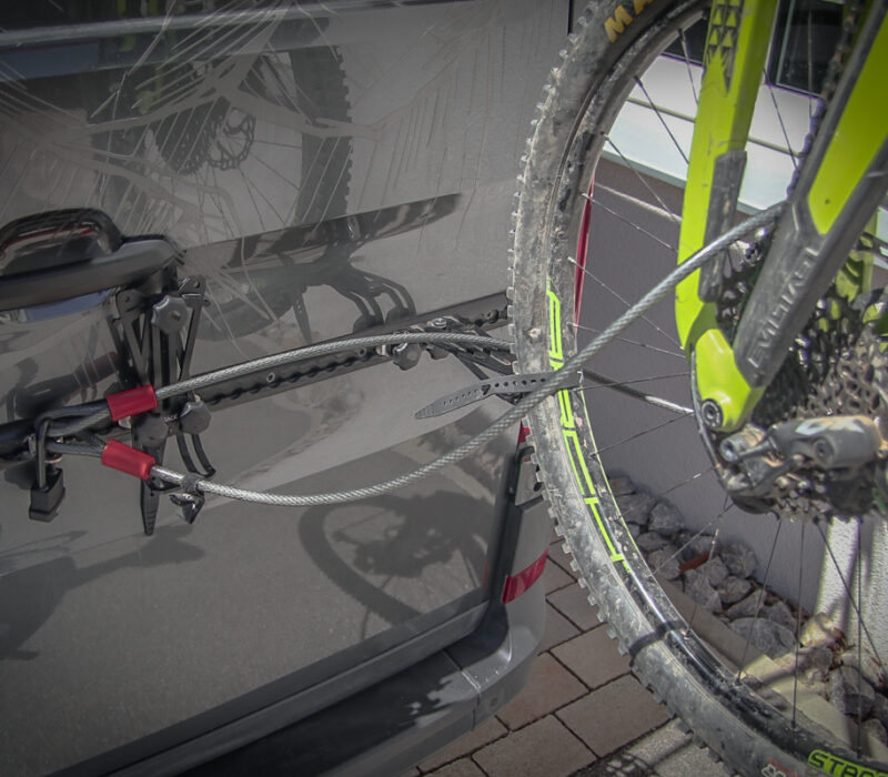 Dieses Bild zeigt, wie du mit den PUSHrack Produkten Lock point, steel cable and padlock dein Rad vor Diebstahl am Fahrradträger schützen kannst.