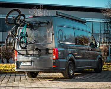 PUSHrack bike rack V3 attached to the rear of a campervan with a gravel bike and a children's bike