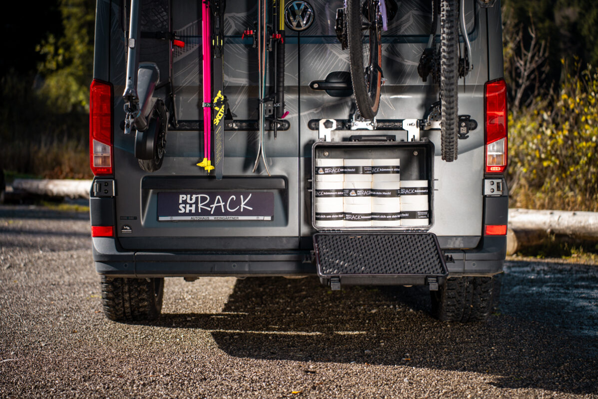 Toilet paper rolls stored in the PUSHrack Box on the PUSHrack Room Extender, mounted on airline rails at the camper rear