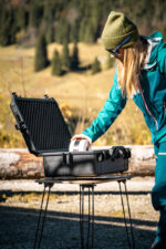 Open PUSHrack box in outdoor use, person taking equipment from a rugged transport box in nature