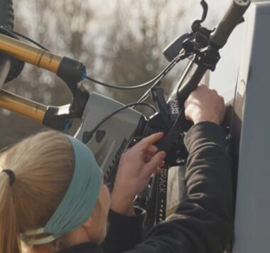 Lici befestigt mit den Straps das Fahrrad am Fahrradträger