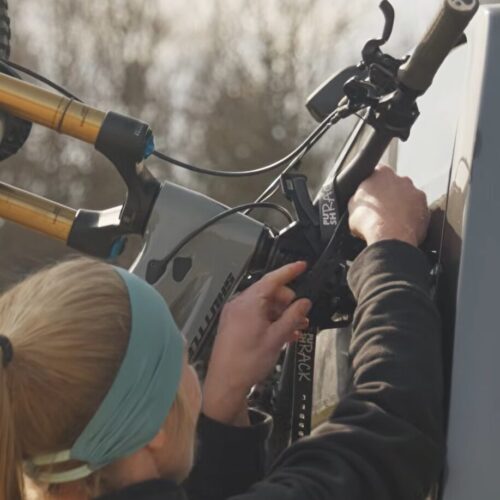 Lici befestigt mit den Straps das Fahrrad am Fahrradträger