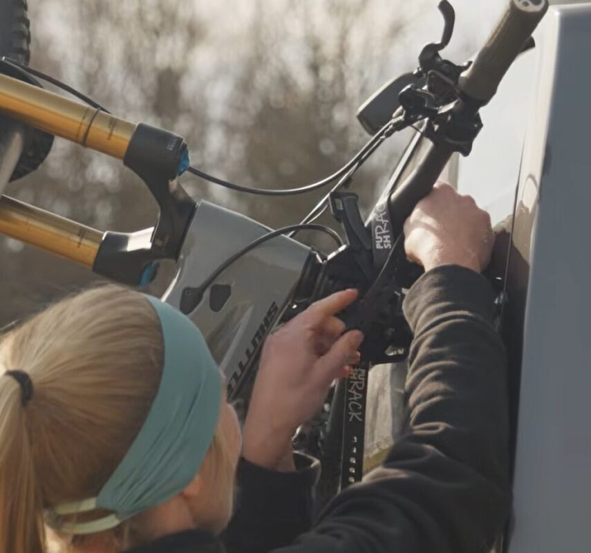 Lici befestigt mit den Straps das Fahrrad am Fahrradträger