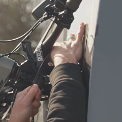 Lici befestigt mit den Straps das Fahrrad am Fahrradträger