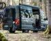 Zu sehen ist ein Camper im Wald, geladen hat er zwei Fahrräder und ein Pupsrack